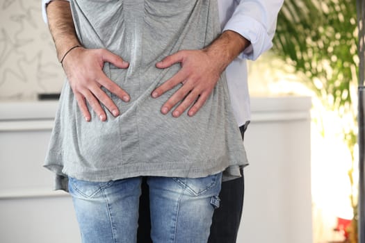 Couple stood hugging in their home