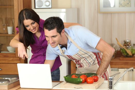 Couple following a recipe on a laptop