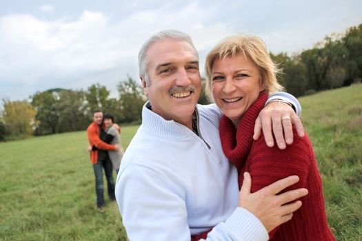 Couples hugging in a field