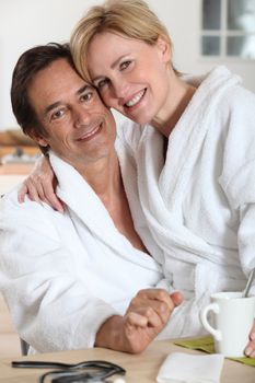 Couple dressed in bathing robes in the kitchen