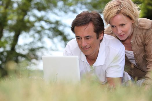 couple with laptop outdoors