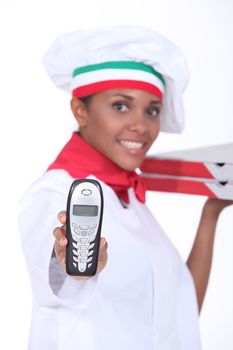 female pizza cook showing a phone