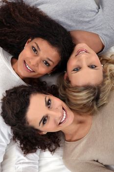 Three female friends laying together