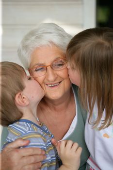 Grandchildren kissing grandma