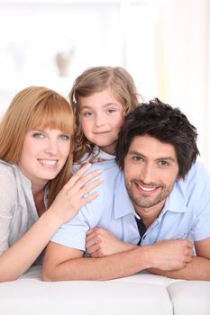 Parents and young daughter on bed together