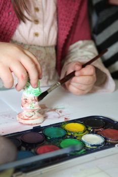 Child painting a plaster figurine