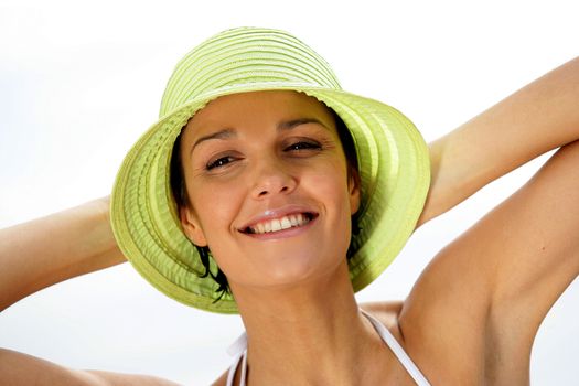 Brunette in hat relaxing at the beach