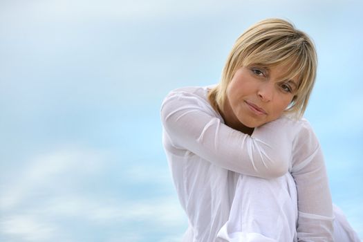 Blond woman sat touching shoulder