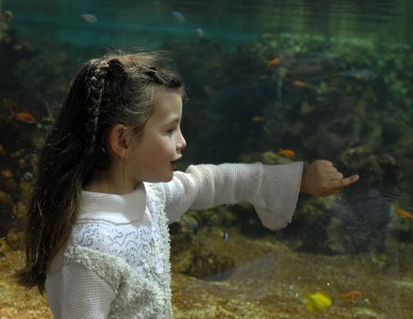 little girl in front of a big tank