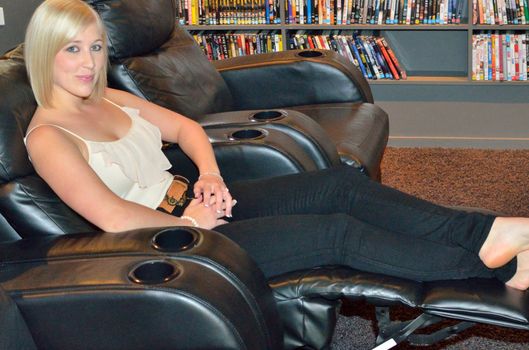 Young lady with a front row seat in a home theatre