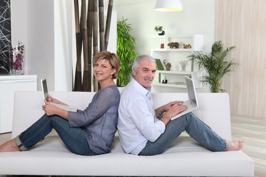 Couple each working on their own laptop