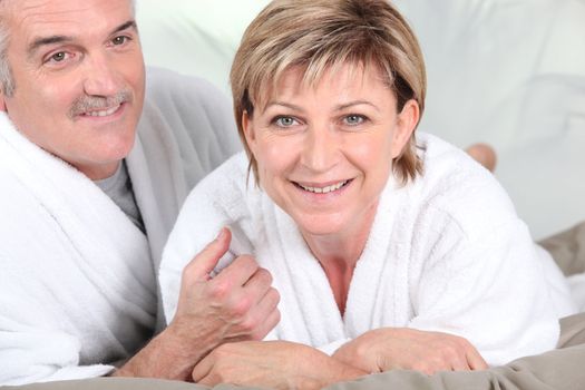 Mature couple in bed with bathrobe