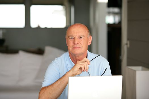 Senior man using a laptop computer at home