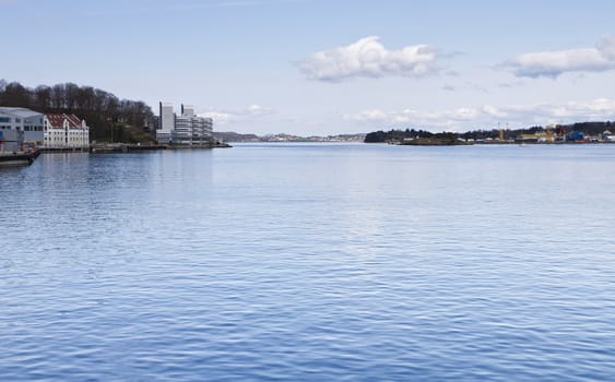 coastline with town and harbor in norway. cloudy sky