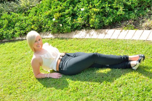 Young lady lying on the green grass in the park