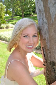 Attractive young lady hugging a gum tree