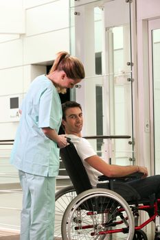 Nurse and patient in wheelchair in front of a lift