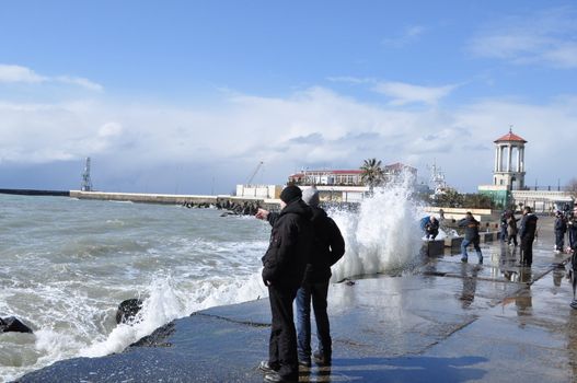 Sea waves breaking on concrete port with spray