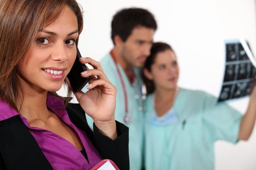 Businesswoman on phone and carers observing an x-ray