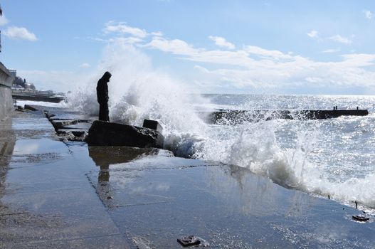 Sea waves breaking on concrete port with spray