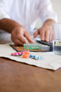 Old lady using pillbox to keep medicine organized