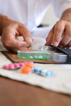 Old person preparing medication for the week ahead