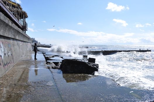 Sea waves breaking on concrete port with spray