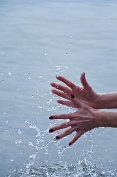 Women's hand with a spray of water