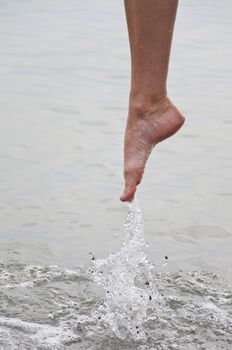 Women's leg with a spray of water