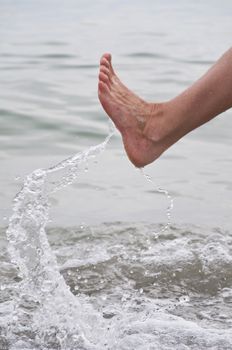 Women's leg with a spray of water