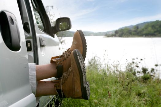 Man snoozing in car parked by lake