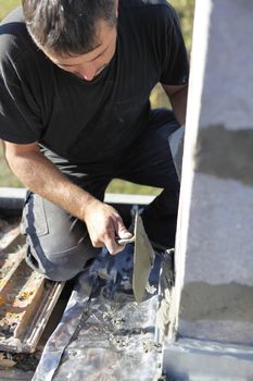 Mason using trowel to spread cement on wall