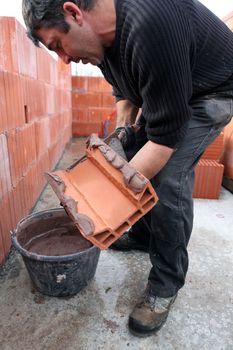 Mason spreading cement on brick