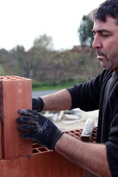 Mason working on unfinished brick wall