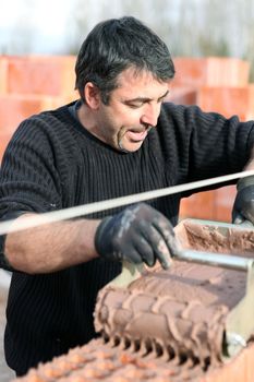 Mason using special device to pour cement on wall