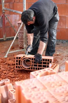 Workman sculpting a brick