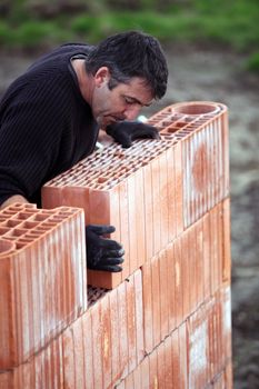 A tradesman laying a brick