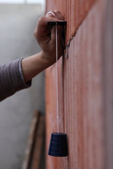 Laborer using plumb-line