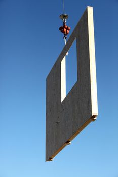 Crane lifting concrete wall