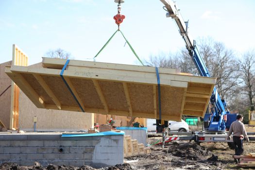 Crane lifting side of house