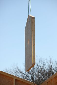 Crane lifting a wooden wall into place