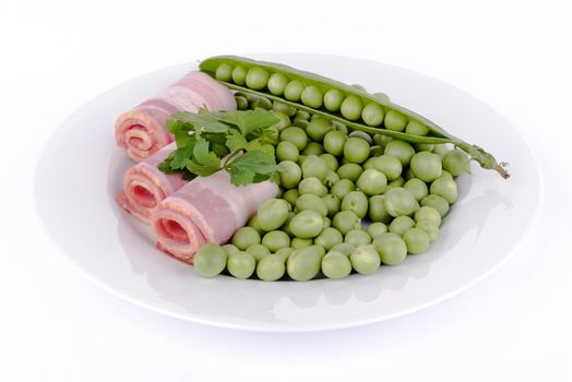 Fresh peas and ham rolls isolsted on background.