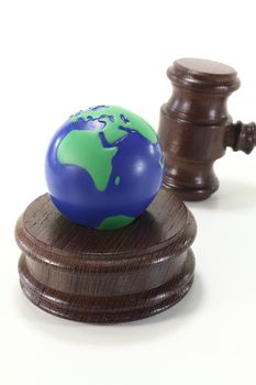 brown judges Gavel of wood with blue and green globe on a light background