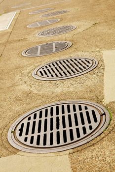 Uneven Line up of Sewer Drains on a sidewalk