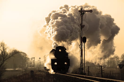 Vintage steam train starting from the station, wintertime
