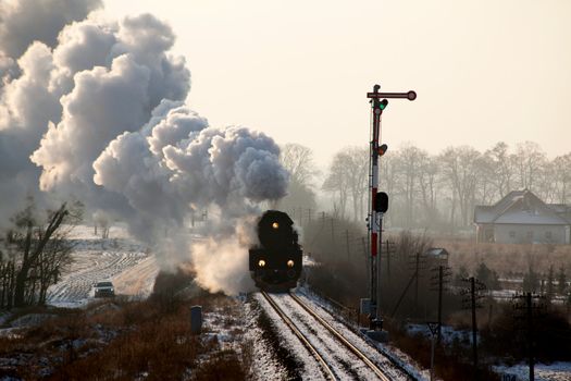 Vintage steam train starting from the station, wintertime
