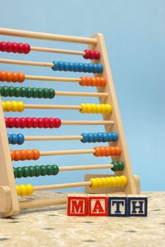 A childs abacus and alphabet blocks to represent the subject of learning math.