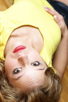 An attractive woman lays on her back while on the floor.