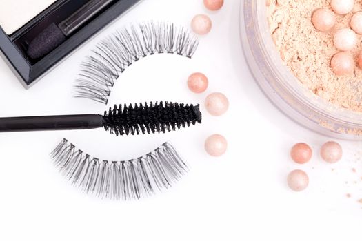 black false eyelashes with mascara and powder, on white background