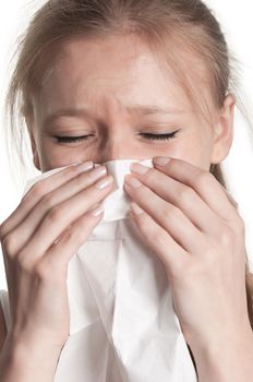 Pale sick woman with a flu, sneezing, in a white background